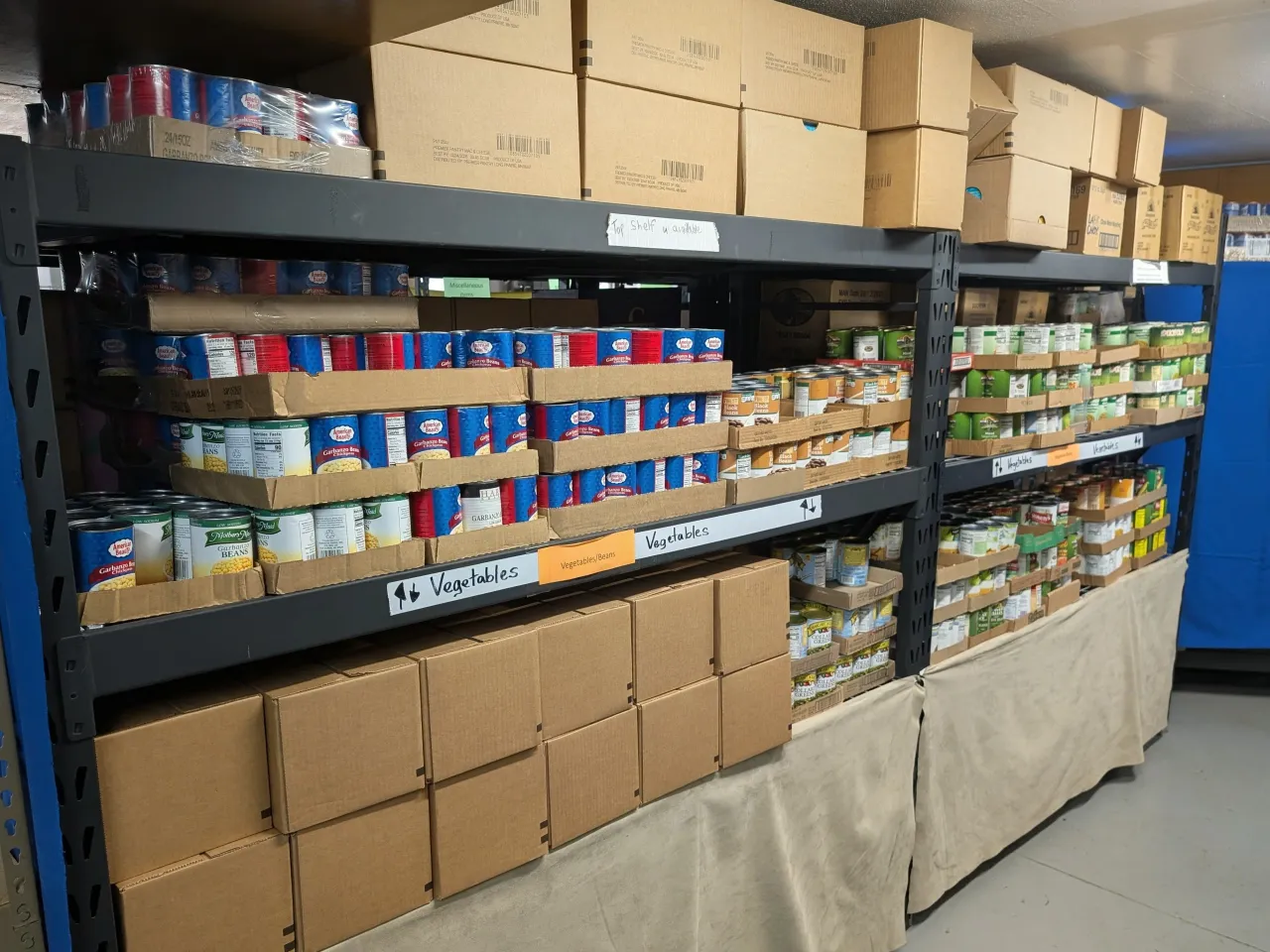 Canned vegetables and dry goods lining the food bank shelves