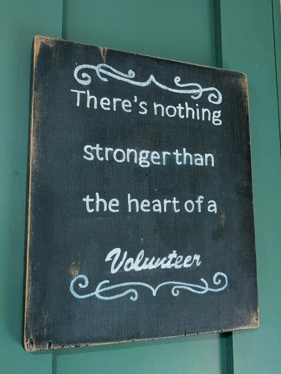 A chalkboard sign reading 'There's nothing stronger than the heart of a Volunteer'
